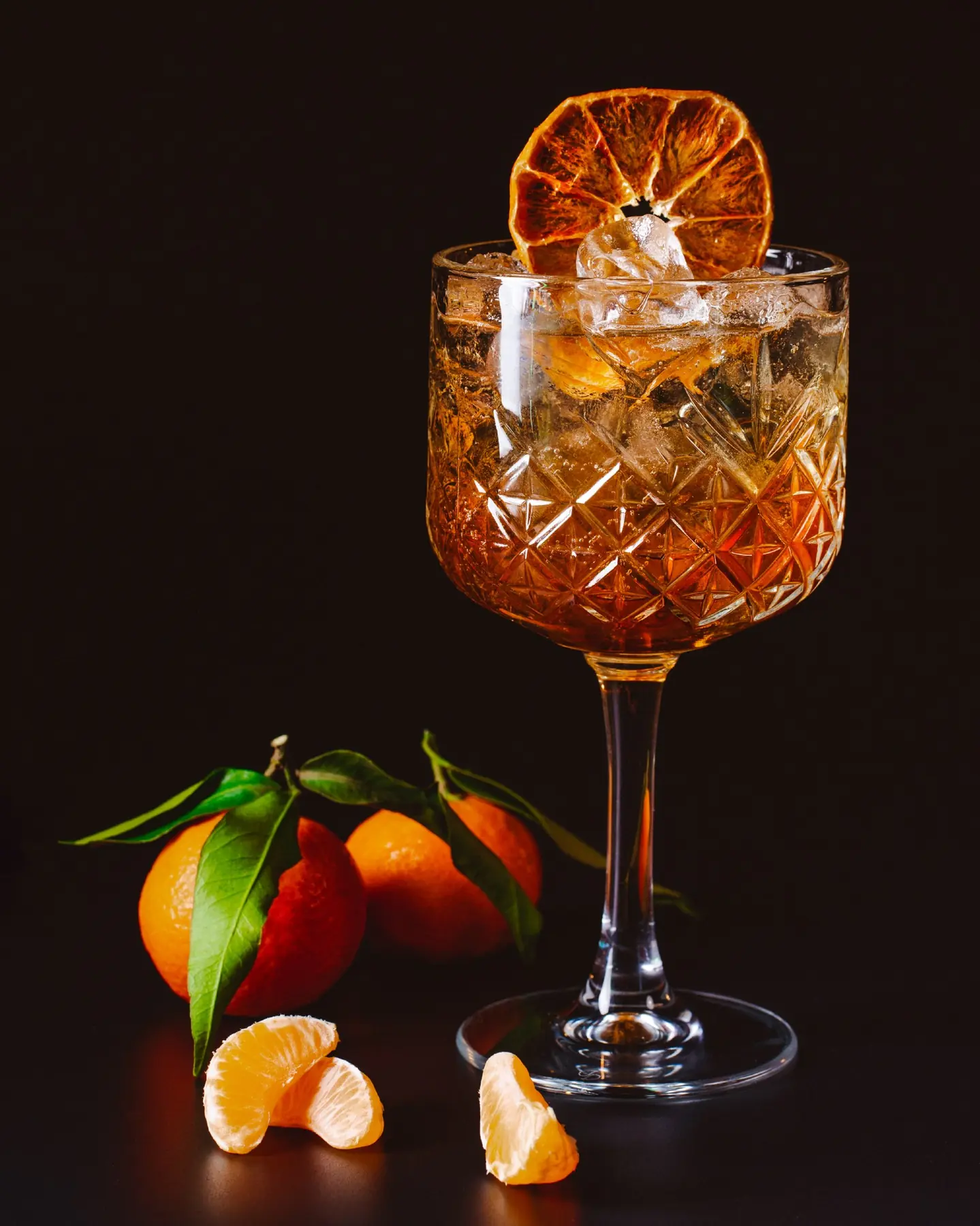 Citrus peel spirals around a cocktail glass in a graphic still life.