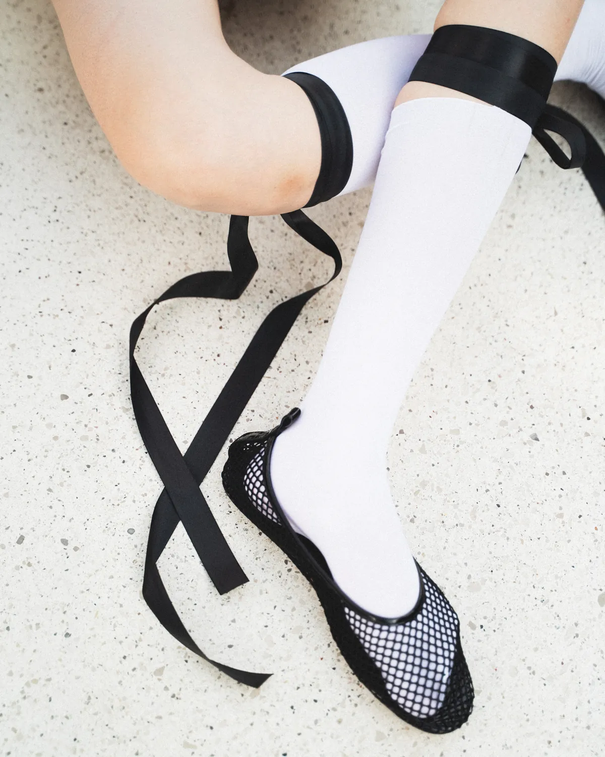 Graphic footwear and layered garments form a vertical fashion composition.
