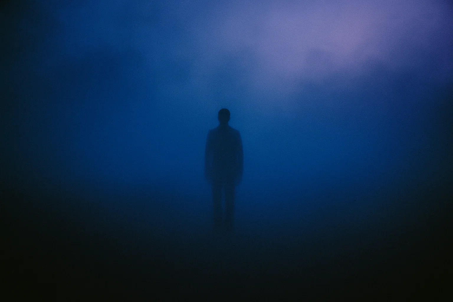 Figura nella nebbia in ambiente blu, atmosfera sospesa